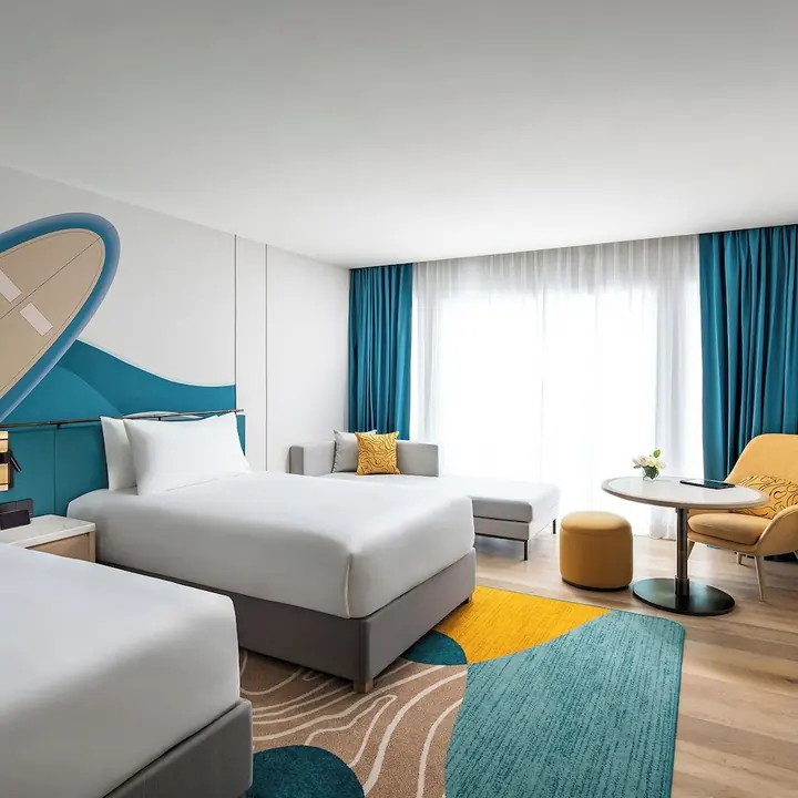 M Social Hotel Phuket의 트윈 침대와 소파가 있는 객실 예시